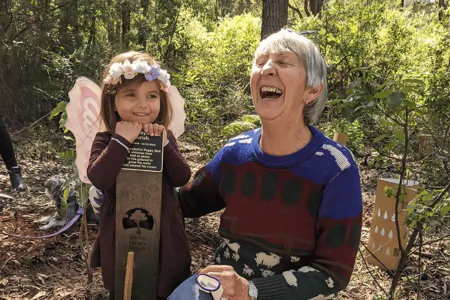 A woman planting A Living Legacy Tree from her husband's ashes in Wellington Dam Living Legacy Forest