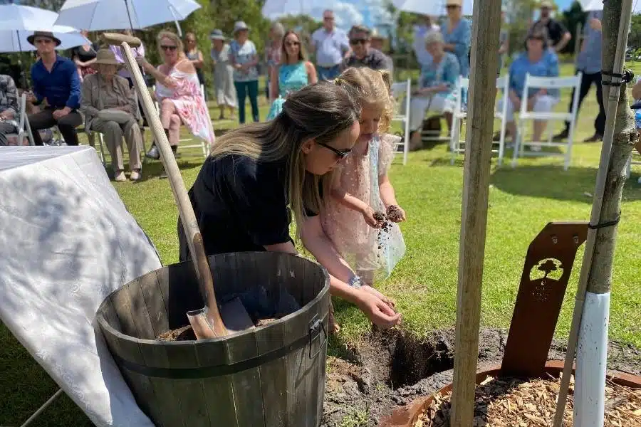 A mom and her daughter planting A Living Legacy Tree at Mornington Green Living Legacy Gardens as it is a unique memorial idea for our dad