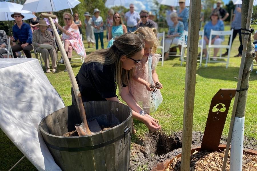 A family put ashes into a tree and bury ashes under tree at Mornington Green Living Legacy Gardens